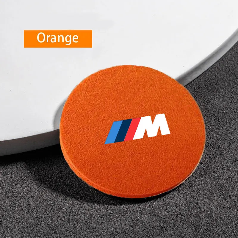 "Orange BMW circular logo on a set of six coasters."