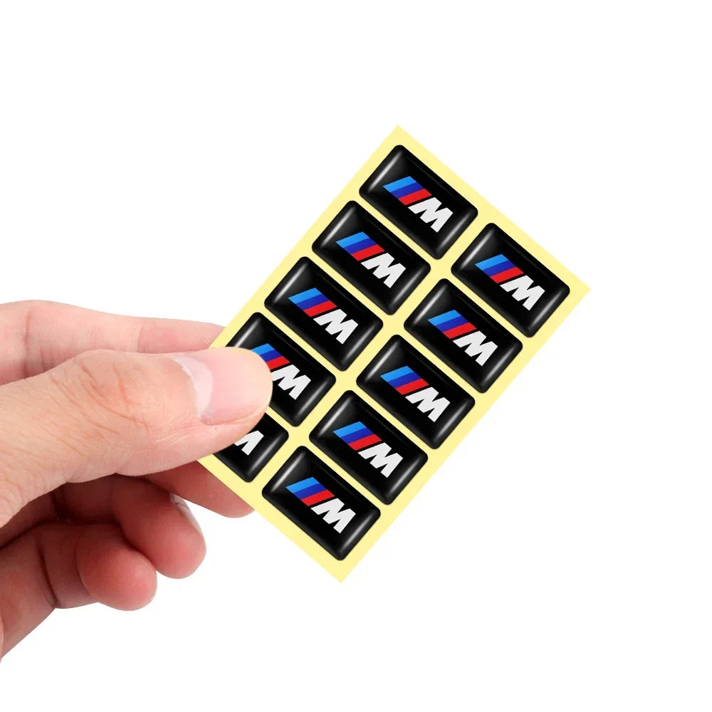 "Set of 2 BMW M emblem 3D epoxy stickers in black and yellow for E36, E46, E90, X5, X6 vehicles."