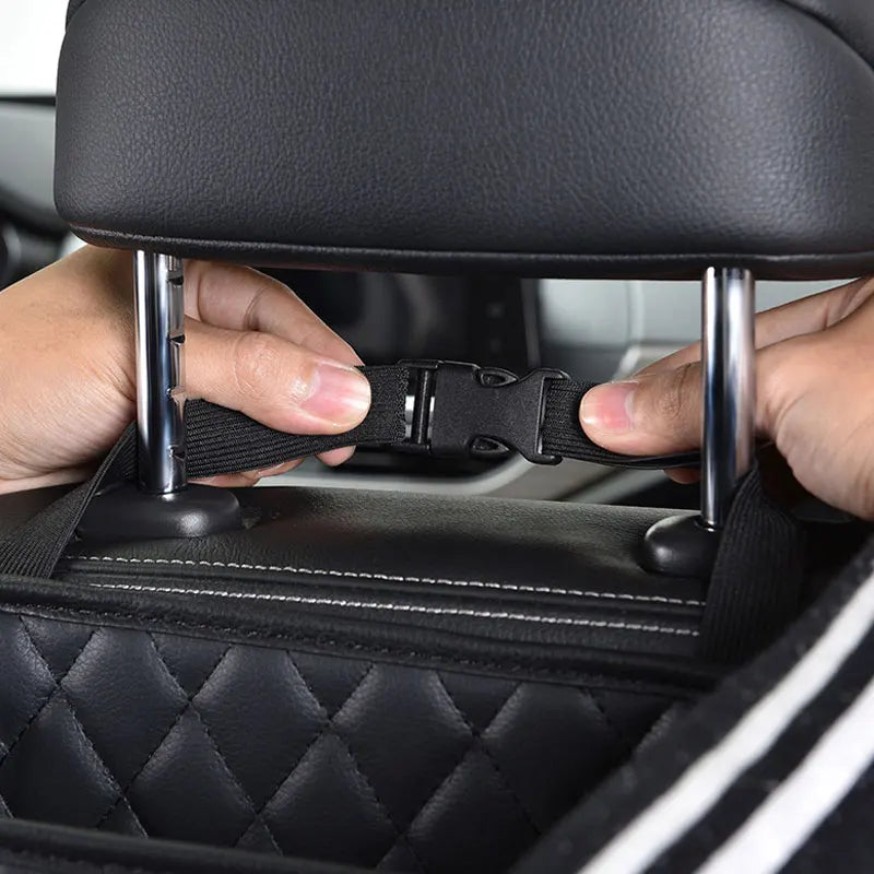 Adult hand near car seat with accessory tool, showing scale. No action or emotion.