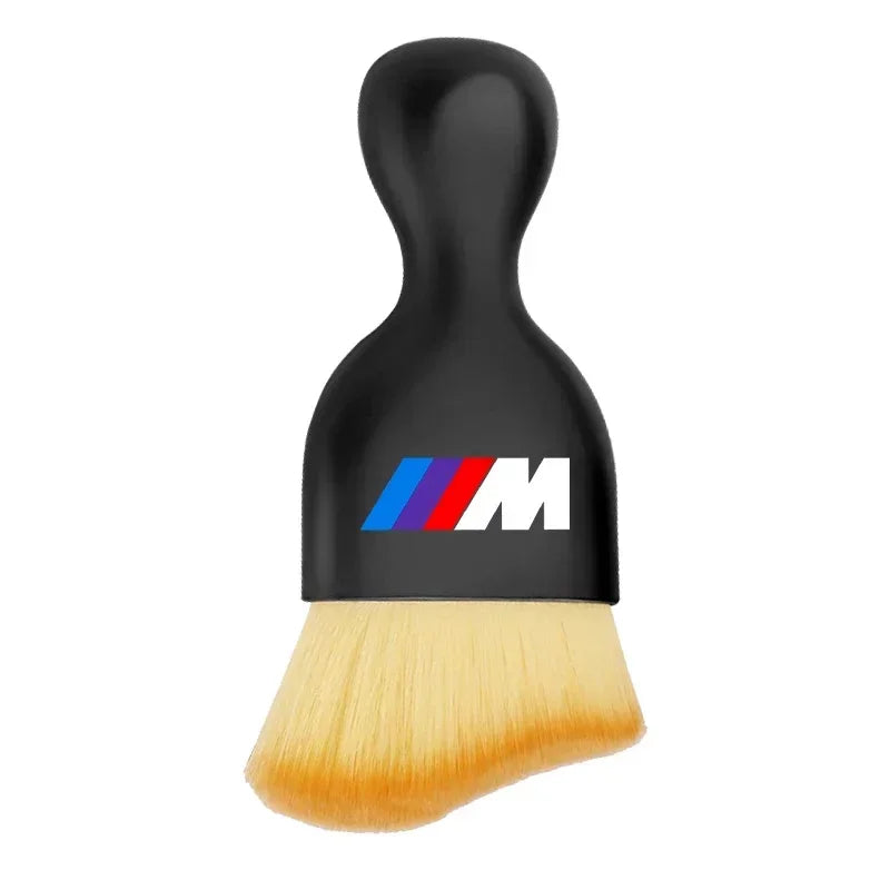 Black fine-tip art brush with a white ergonomic handle, featuring a modern red and blue logo at the base.