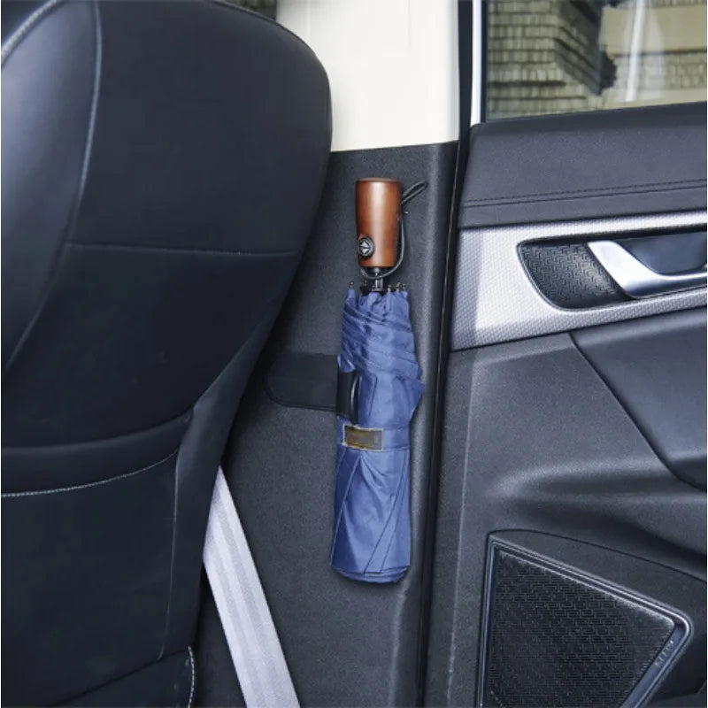 Car trunk umbrella holder mounted near handle. Blue umbrella displayed. Fits most models. Tool-less installation. Dimensions:
