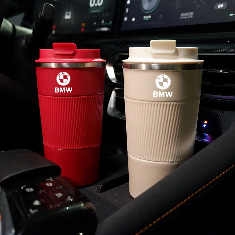 Two BMW M Sport travel mugs on a dashboard, ready for your morning commute in E-Series and F-Series models.