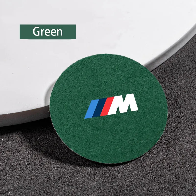 "Green circular coaster featuring the 'M' logo in the center."