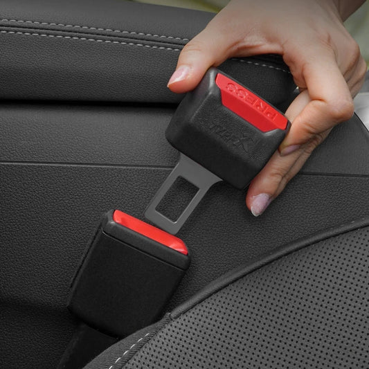 Close-up of hand holding car seat belt with lock plug insert. Safety accessory for belt clip modification. Fits 1/2pc models.