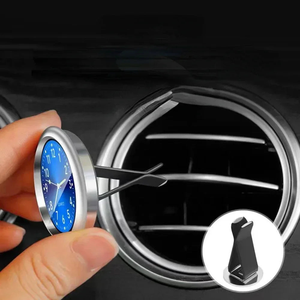 'Mini luminous car clock. Adhesive backing. Suitable for air vents or dashboard. Measurements: 10cm x 4cm.'
