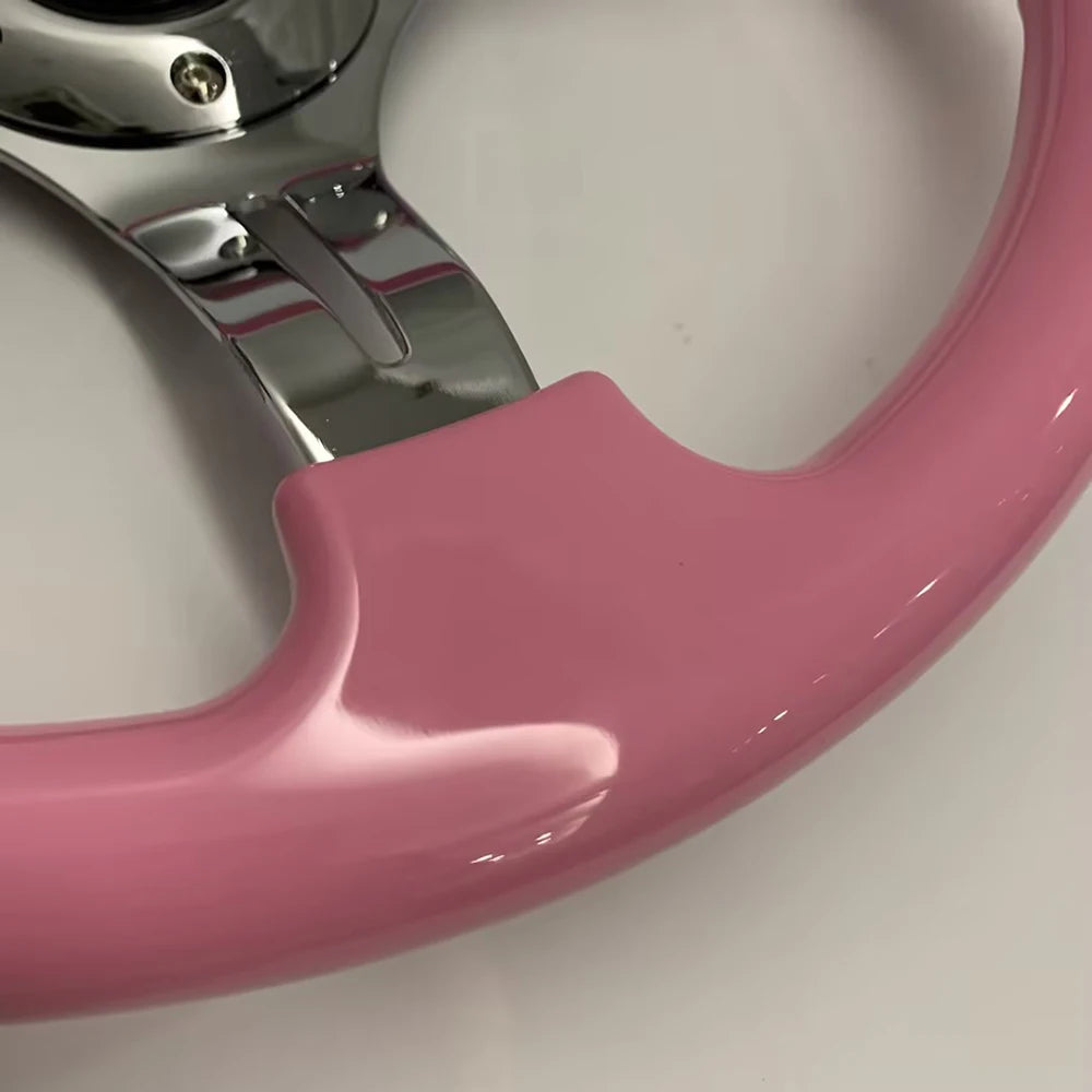 'Pink 14" ABS steering wheel on aluminum alloy frame with silver-accented spokes.'