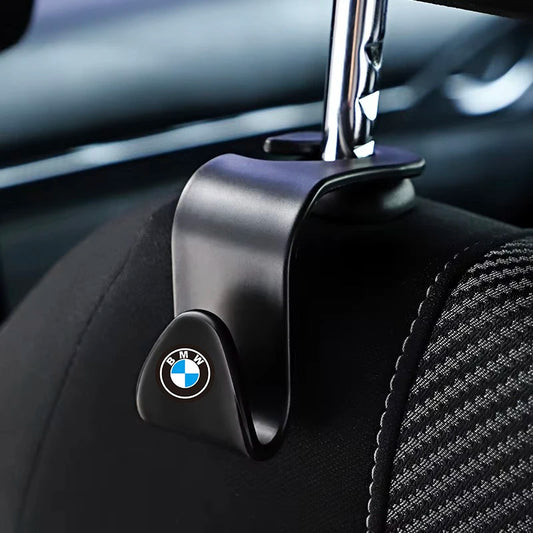 "Black BMW seat belt connector hooks on empty car seat."

or

"BMW Car Seat Back: Black seat belt hook connectors."