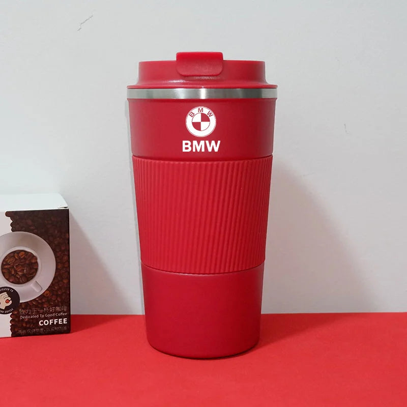 Red BMW M Sport travel mug on a table, next to an open box of coffee.