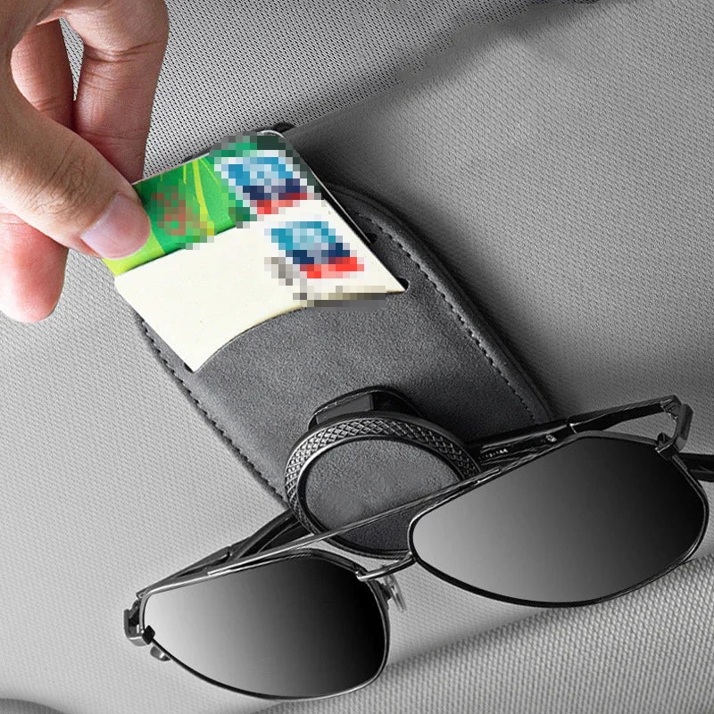 Adult hand holding credit card and sunglasses near car sun visor organizer, showcasing product scale. No distractions, focuse