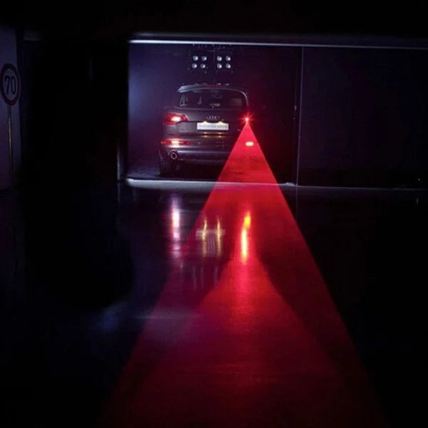 "Red LED fog tail light illuminating on stationary vehicle in a garage."
