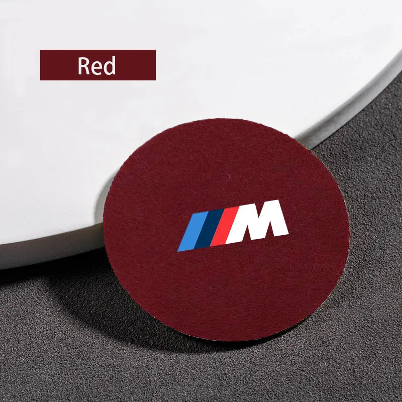 A distinctly red BMW logo is prominently displayed against a pristine white automobile body.